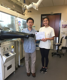 student and professor in lab with award