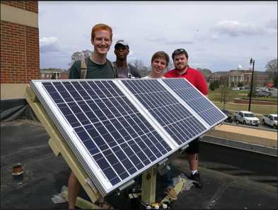 students hold a solar pannel